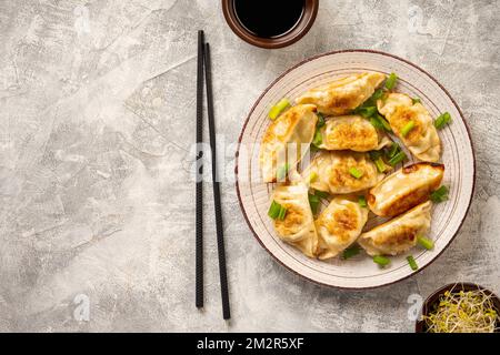 Gyoza, boulettes japonaises poêlées, sur fond clair. Banque D'Images