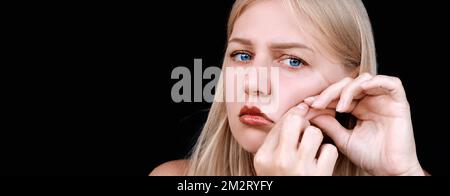 Deuxième menton, obésité. Portrait d'une femme de 30 ans tirant la peau sur son menton regarde dans l'appareil photo avec un aspect frustré. Problèmes de Banque D'Images