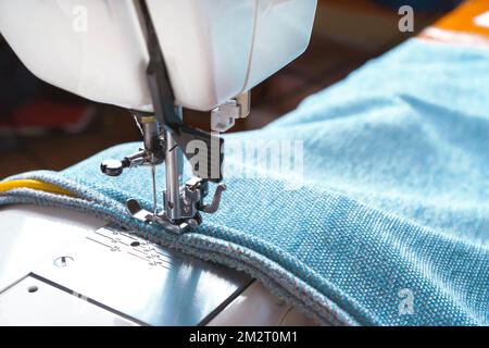 Machine à coudre pied de pression en acier avec point d'aiguille avec fil  sur tissu bleu, textile sur plaque d'aiguille. Confection de vêtements  Photo Stock - Alamy