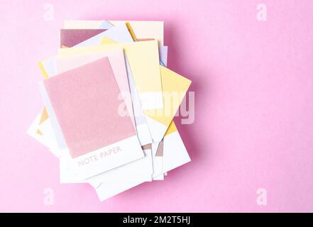 Papiers adhésifs vierges colorés sur fond rose pour votre texte ou votre message. Banque D'Images