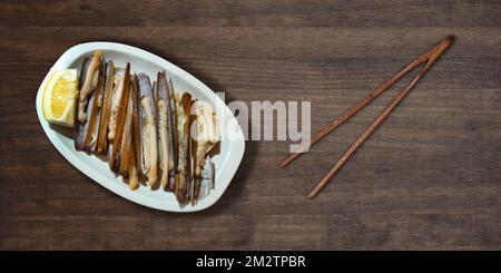 Pantaches de Razor grillées au citron prêtes à manger servies au plateau blanc sur table sombre typiquement espagnol Tapa Banque D'Images