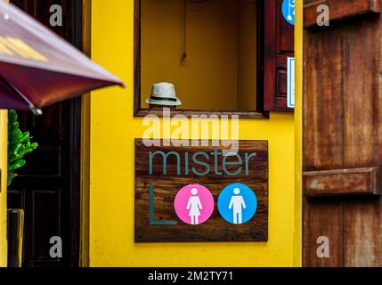 Seul un chapeau est vu à la fenêtre de paye des toilettes publiques dans la vieille ville, Hoi an, Vietnam. Banque D'Images