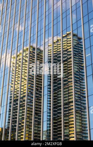 Vue abstraite de deux immeubles de bureaux modernes reflétés dans les fenêtres d'un autre immeuble de bureaux moderne Banque D'Images