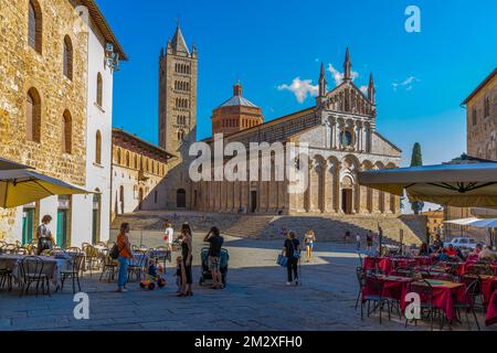 Restaurants de rue sur la Piazza Garibaldi, à l'arrière la cathédrale de San Cerbone dans la lumière du soir, Massa Marittima, Toscane, Italie Banque D'Images