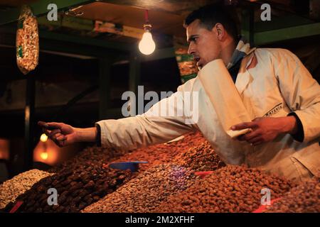 Marrakech, Maroc : 28 mars 2016 - Un homme marocain vend des noix et offre un échantillon gratuit sur le marché de marrakech de la Jamaa el Fna Banque D'Images