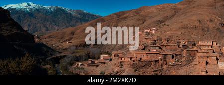 Vue panoramique sur le petit village au milieu des montagnes de l'Atlas, au Maroc avec montagne enneigée en arrière-plan. Photo de haute qualité Banque D'Images