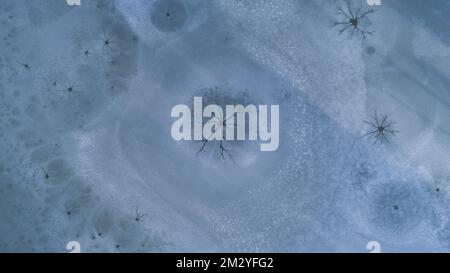 Image de drone de trous de vapeur à la surface de glace d'un lac gelé causée par la convection dans l'eau, Swabia, Bavière, Allemagne Banque D'Images