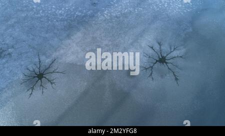 Image de drone de trous de vapeur à la surface de glace d'un lac gelé causée par la convection dans l'eau, Swabia, Bavière, Allemagne Banque D'Images