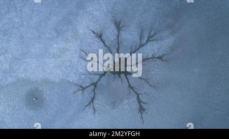 Image de drone de trous de vapeur à la surface de glace d'un lac gelé causée par la convection dans l'eau, Swabia, Bavière, Allemagne Banque D'Images