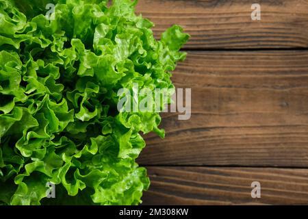 Tête de salade de laitue verte sur une table de cuisine en bois, vue du dessus. Copier l'espace pour le texte. Alimentation saine. Banque D'Images