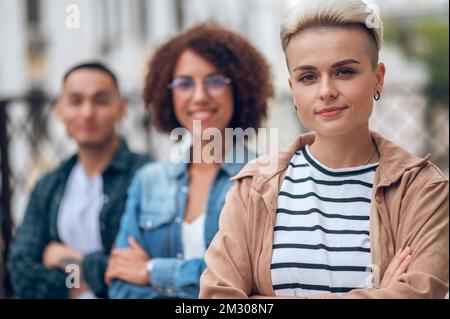 Paisible femme caucasienne en compagnie de personnes biraciales Banque D'Images