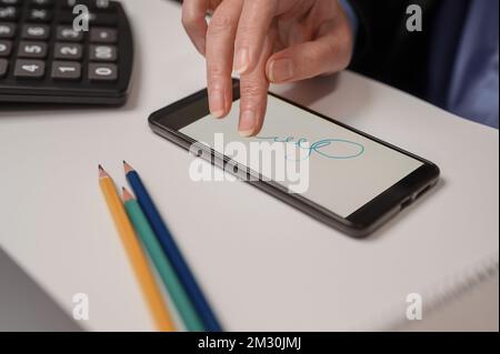 une femme signe un contrat à distance dans un téléphone portable. concept de signature électronique Banque D'Images