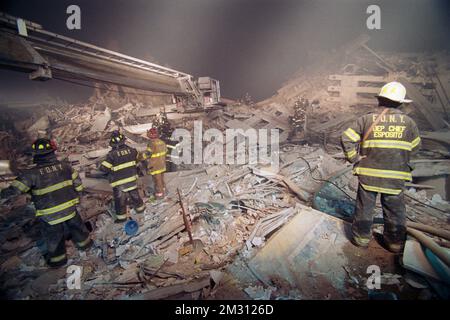 Un sous-chef du service des incendies de la ville de New York supervise et regarde comme membres de FDNY Ladder Company 124 enlever les outils et l'équipement de la « pile » Banque D'Images