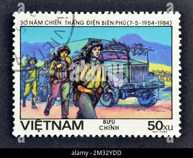 Timbre-poste annulé imprimé par le Vietnam, qui montre des civils transportant des provisions, victoire à Dien bien Phu, 30th anniversaire, vers 1984. Banque D'Images