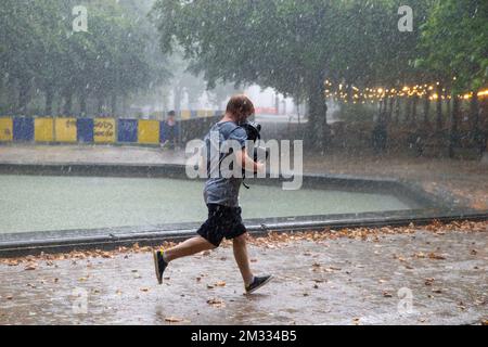 L'illustration montre un homme qui court à couvert, sous de fortes pluies, au parc de Bruxelles, à Bruxelles, le dimanche 16 août 2020. Le Royal Meteorological Institute KMI - IRM a classé la situation "code orange" avec de fortes précipitations et des orages dans tout le pays. BELGA PHOTO NICOLAS MATERLINCK Banque D'Images