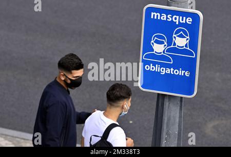 L'illustration montre deux hommes portant un masque lorsqu'ils passent un signe indiquant 'masque obligatoire' (obligation de porter un masque buccal), à Liège, le mercredi 02 septembre 2020. Les mesures actuelles de crise du coronavirus exigent que les gens gardent 1,5m distances et portent des masques buccaux dans les transports publics et dans les magasins, entre autres endroits. BELGA PHOTO ERIC LALMAND Banque D'Images