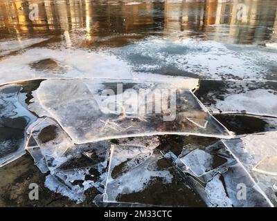 Des feuilles de glace sont cassées sur un lac de navigation étang de canard hiver images saisonnières, temps froid, temps glacé, chutes de températures, changement climatique dangereux Banque D'Images