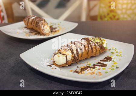 Gâteau italien à la cannoli aux pistaches et au chocolat deux morceaux sur des assiettes différentes Banque D'Images