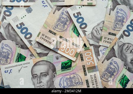 Argent comptant monnaie ukrainienne hryvnia cinq cents hryvnia mille billets et pièces monnaie revenus concept dollars sur un fond bleu Banque D'Images