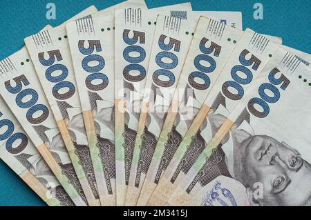 Argent comptant monnaie ukrainienne hryvnia cinq cents hryvnia mille billets et pièces monnaie revenus concept dollars sur un fond bleu Banque D'Images