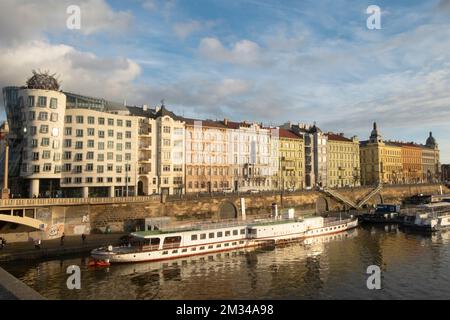 Maison dansante et bateaux sur la Vltava au coucher du soleil, Prague, République Tchèque. Banque D'Images