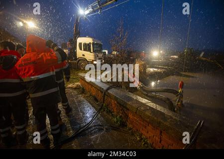 L'illustration montre le service de protection civile qui installe une pompe à eau pendant le niveau d'eau élevé de la rivière 'Shelde' à Wichelen, le samedi 30 janvier 2021. Après les fortes pluies des derniers jours, le niveau d'eau de plusieurs rivières augmente, ce qui pourrait entraîner des inondations dans certaines régions. BELGA PHOTO NICOLAS MATERLINCK Banque D'Images