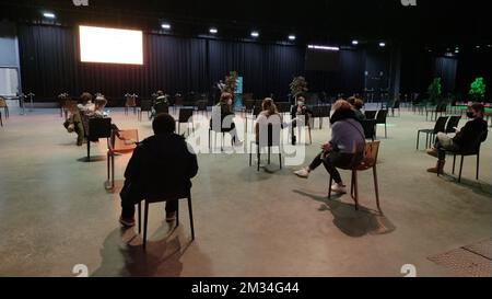 L'illustration montre des personnes assises dans la salle d'attente au début des vaccinations dans le hall Brabanthal de Louvain, l'un des endroits où un village de vaccination est installé, vendredi 19 février 2021. BELGA PHOTO INE GILLIS Banque D'Images