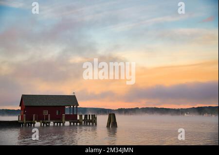 Une petite maison en bois rouge sur le quai sur le fleuve Connecticut, dans un matin de septembre brumeux Banque D'Images