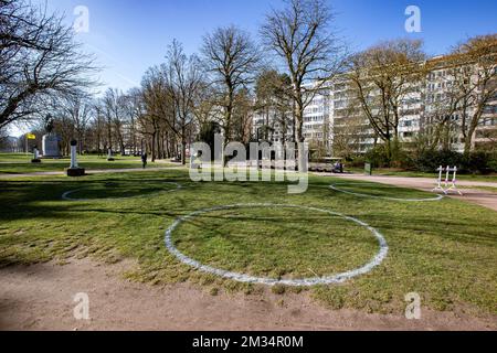 L'illustration montre les cercles sociaux de distance installés sur le Zuidpark, dans le centre de Gand, le lundi 29 mars 2021. Avec les températures élevées des derniers jours, les gens se sont enfermés dans les parcs publics et les places, souvent sans respecter la distance sociale et d'autres règles de sécurité corona. Pour encourager les gens à respecter les distances de sécurité, Gand a marqué 6m cercles de diamètre pour de petites « bulles » de quatre personnes maximum. BELGA PHOTO KURT DESPLENTER Banque D'Images