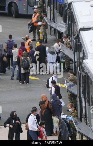 L'illustration montre des gens qui passent dans des autobus à l'arrivée d'un avion affrété d'Air Belgium Airbus A340 transportant des personnes évacuées d'Afghanistan, à l'aéroport militaire de Melsbroek, le jeudi 26 août 2021. La mission d'évacuation militaire belge « l'opération Red Kite » transporte des avions de défense entre la capitale pakistanaise Islamabad et Kaboul en Afghanistan, pour faire sortir les Belges et leurs familles, mais aussi les Afghans, comme les interprètes, les fixateurs et les employés des organisations de défense des droits de l'homme, en toute sécurité hors d'Afghanistan. BELGA PHOTO NICOLAS MATERLINCK Banque D'Images