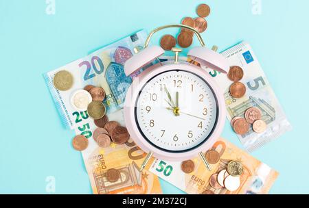 Réveil avec billets et pièces en euros, inflation, récession et crise financière, coûts de vie élevés Banque D'Images