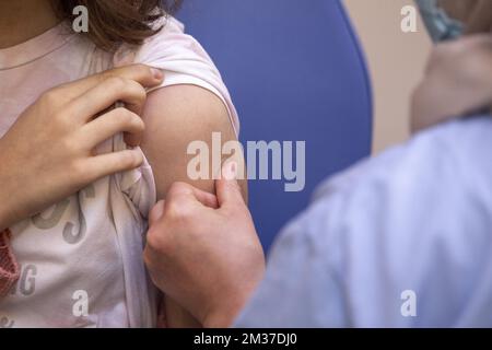 L'illustration montre un enfant qui reçoit son vaccin lors de l'ouverture de la vaccination pour les enfants de cinq à onze ans, le mercredi 22 décembre 2021, au centre de vaccination et de test de Pacheco. BELGA PHOTO NICOLAS MATERLINCK Banque D'Images