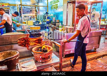 BANGKOK, THAÏLANDE - 23 AVRIL 2019 : le jeune cuisinier torréfaction canard de pékin dans la cuisine extérieure du restaurant chinois à Chinatown, sur 23 avril à Bang Banque D'Images
