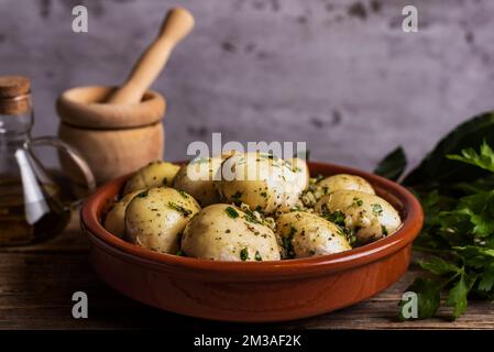Champignons crus dans un plat de cuisson en argile, assaisonnés et prêts à aller au four. Banque D'Images