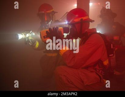 ÉTATS-UNIS Des marins de la Marine et un pompier local participent à un exercice d'incendie à bord du porte-avions USS John C. Stennis (CVN 74), le 8 décembre 2022. Le John C. Stennis est à Newport News, chantier naval qui effectue le ravitaillement en carburant et la révision du complexe pour préparer le navire à la deuxième moitié de sa durée de vie de 50 ans. (É.-U. Photo de la marine par Sarah Mead, spécialiste des communications de masse, maître de classe 3rd) Banque D'Images