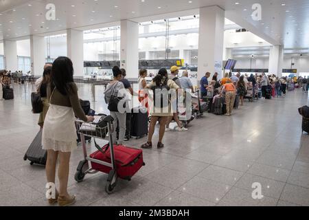 L'illustration montre les passagers qui attendent dans une longue file d'attente dans le hall des départs de l'aéroport de Bruxelles, à Zaventem, le samedi 23 juillet 2022. Quelque 80 vols ont été annulés en Belgique. Il concerne les vols avec un équipage belge. Les autres vols partent avec un équipage de pays où il n'y a pas de grève. Les raisons de la grève de ce week-end sont les mêmes que celles de l'action de fin juin. Les pilotes se sentent mal compris et s'attendent à une augmentation de salaire après une remise de 20 pour cent pendant la crise corona. BELGA PHOTO NICOLAS MATERLINCK Banque D'Images