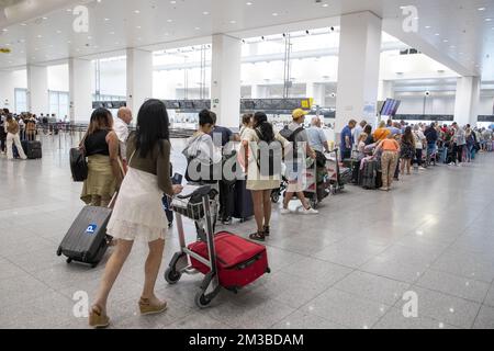 L'illustration montre les passagers qui attendent dans une longue file d'attente dans le hall des départs de l'aéroport de Bruxelles, à Zaventem, le samedi 23 juillet 2022. Quelque 80 vols ont été annulés en Belgique. Il concerne les vols avec un équipage belge. Les autres vols partent avec un équipage de pays où il n'y a pas de grève. Les raisons de la grève de ce week-end sont les mêmes que celles de l'action de fin juin. Les pilotes se sentent mal compris et s'attendent à une augmentation de salaire après une remise de 20 pour cent pendant la crise corona. BELGA PHOTO NICOLAS MATERLINCK Banque D'Images