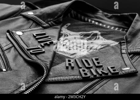 gros plan pour vivre et faire du vélo lettrage sur la veste en cuir de motard et le mouchoir de crâne. style moto, photographie en noir et blanc Banque D'Images