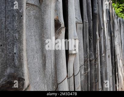 Fermé jusqu'à la texture de mur en bambou gris avec quelques feuilles en arrière-plan Banque D'Images