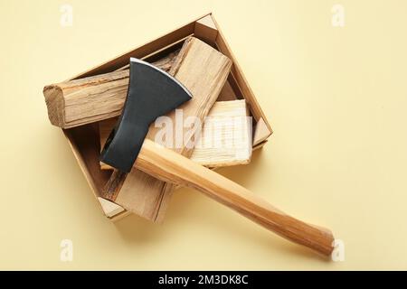 Hache avec bois de chauffage sur fond jaune Banque D'Images