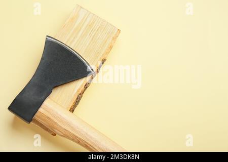 Hache avec bois de chauffage sur fond jaune Banque D'Images