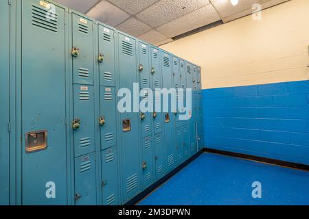 Vestiaires non-descript avec vieux salle de gym en métal bleu, gymnase, casiers avec vieux plafond. Banque D'Images