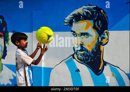 Non exclusif: 14 décembre 2022 à Sylhet, Bangladesh: De jeunes fans argentins célébrant, pose devant une fresque de son héros, Lionel Messi, gagne sur Cro Banque D'Images