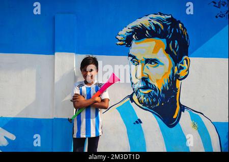 Non exclusif: 14 décembre 2022 à Sylhet, Bangladesh: De jeunes fans argentins célébrant, pose devant une fresque de son héros, Lionel Messi, gagne sur Cro Banque D'Images