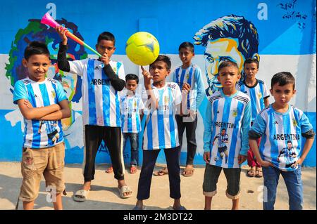 Non exclusif: 14 décembre 2022 à Sylhet, Bangladesh: De jeunes fans argentins célébrant, pose devant une fresque de son héros, Lionel Messi, gagne sur Cro Banque D'Images