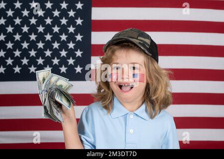 Argent américain. Portrait de l'enfant avec des billets d'argent. Enfant avec de l'argent. Les enfants apprennent la responsabilité financière à économiser de l'argent. Drapeau américain Banque D'Images