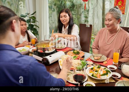 Grande famille qui apprécie la fête du nouvel an chinois et qui mange de la cuisine traditionnelle à la maison Banque D'Images