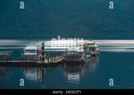 Certains bateaux sur le lac sont amarrés à la jetée en bois. Le lac est très calme. Jetée de Chaowu, zone panoramique nationale du lac Sun Moon. Nantou County, Taïwan Banque D'Images