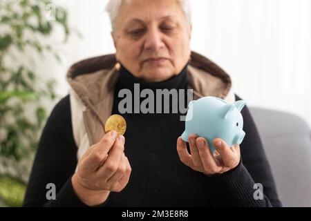 Gros plan d'une femme âgée tenant une caisse d'argent de porc. Femme âgée mains tenant une porcgybank. Concept d'économie d'argent pour les personnes âgées. Banque D'Images