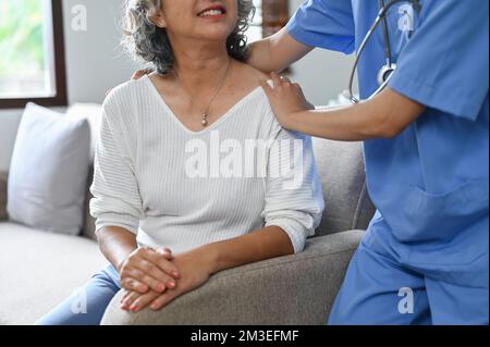 Image rognée, Une femme soignante ou une infirmière qui rend visite à une femme âgée de 60 ans malade qui prend sa retraite à la maison. Banque D'Images